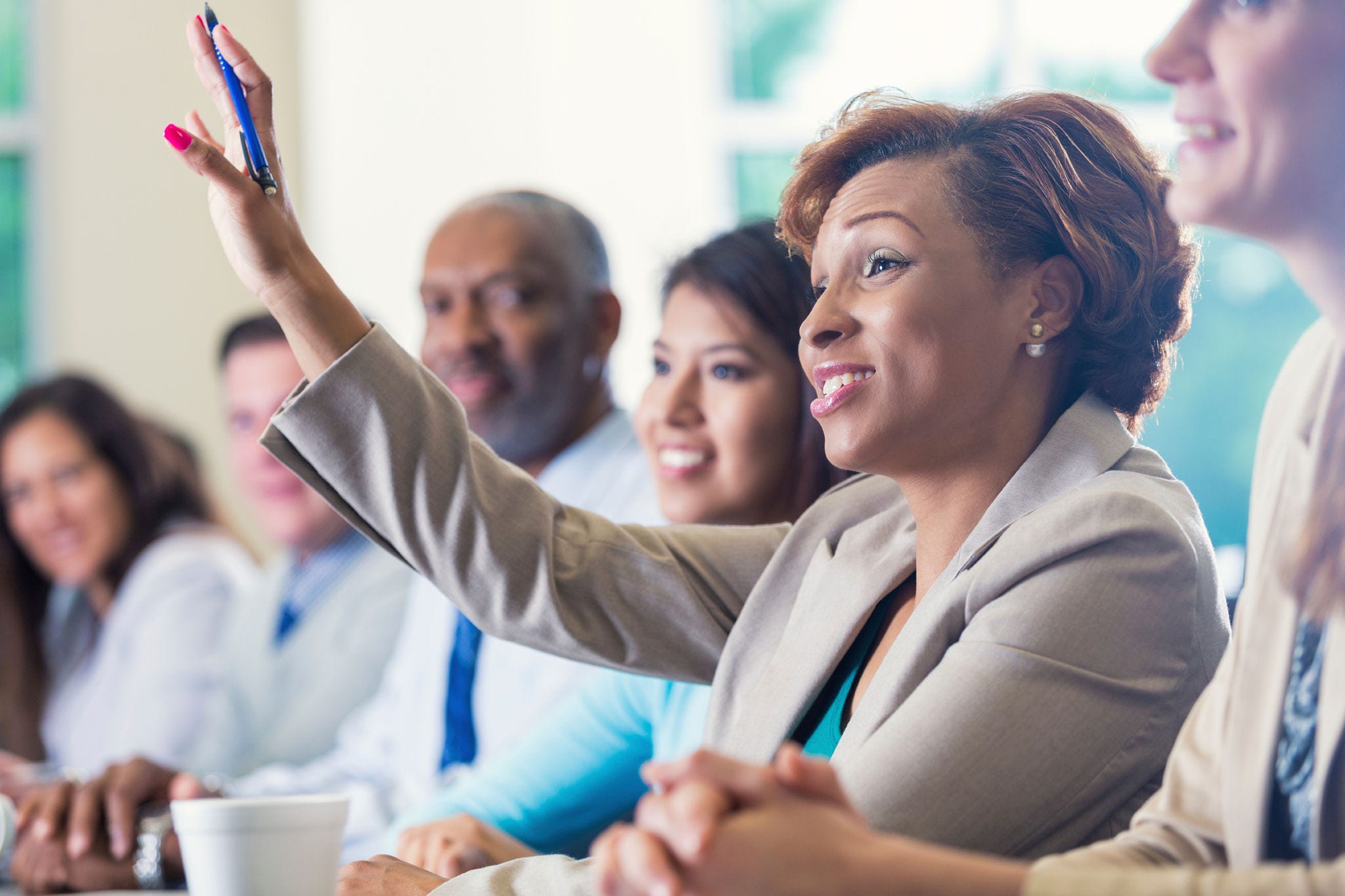 Woman raising hand in group